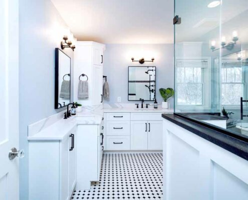 master bathroom with mosaic tile floor and white cabinetry