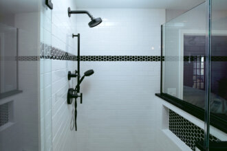 white tile shower with black accents