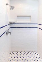 shower with white subway tile and blue accent lines