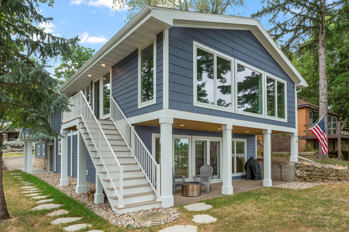 blue lake home with white trim and deck